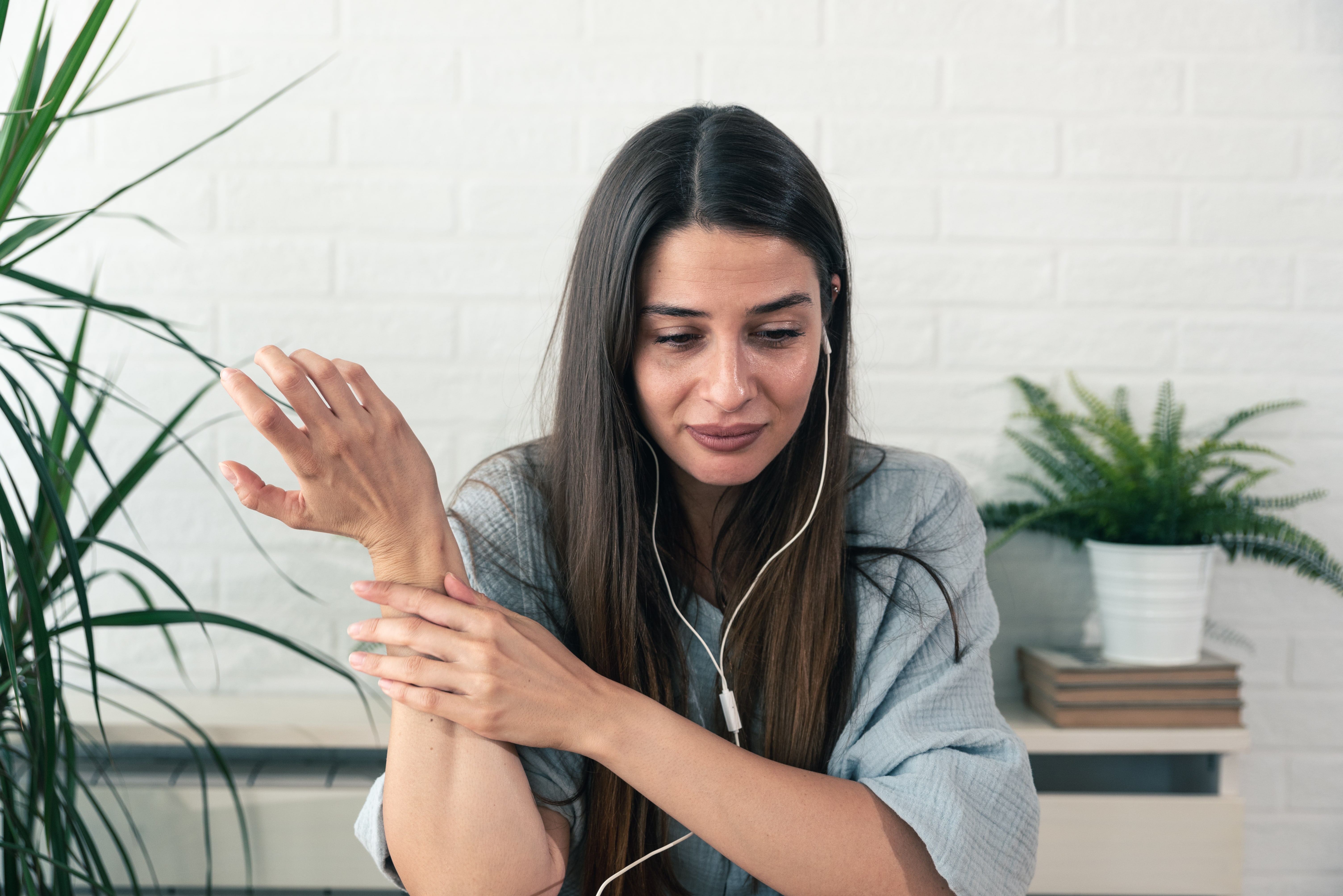 Young sad crying woman testimony on online psychotherapy via video call on the laptop computer where she sitting at her home and talking with doctor psychologist telling her problems